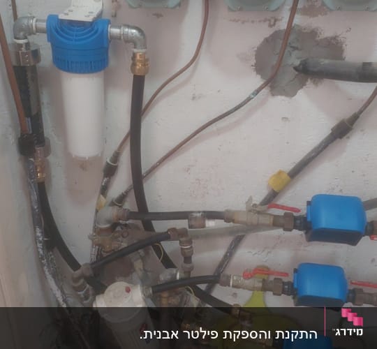 מערכת צנרת עם מדי מים ומסננים כחולים